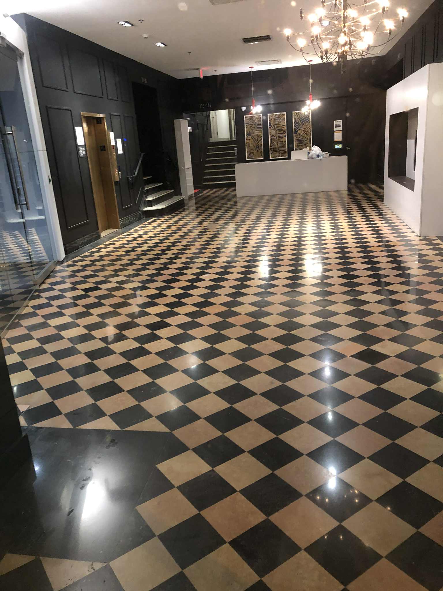 Marble polishing and floor repair showing mirror finish on Carrara marble